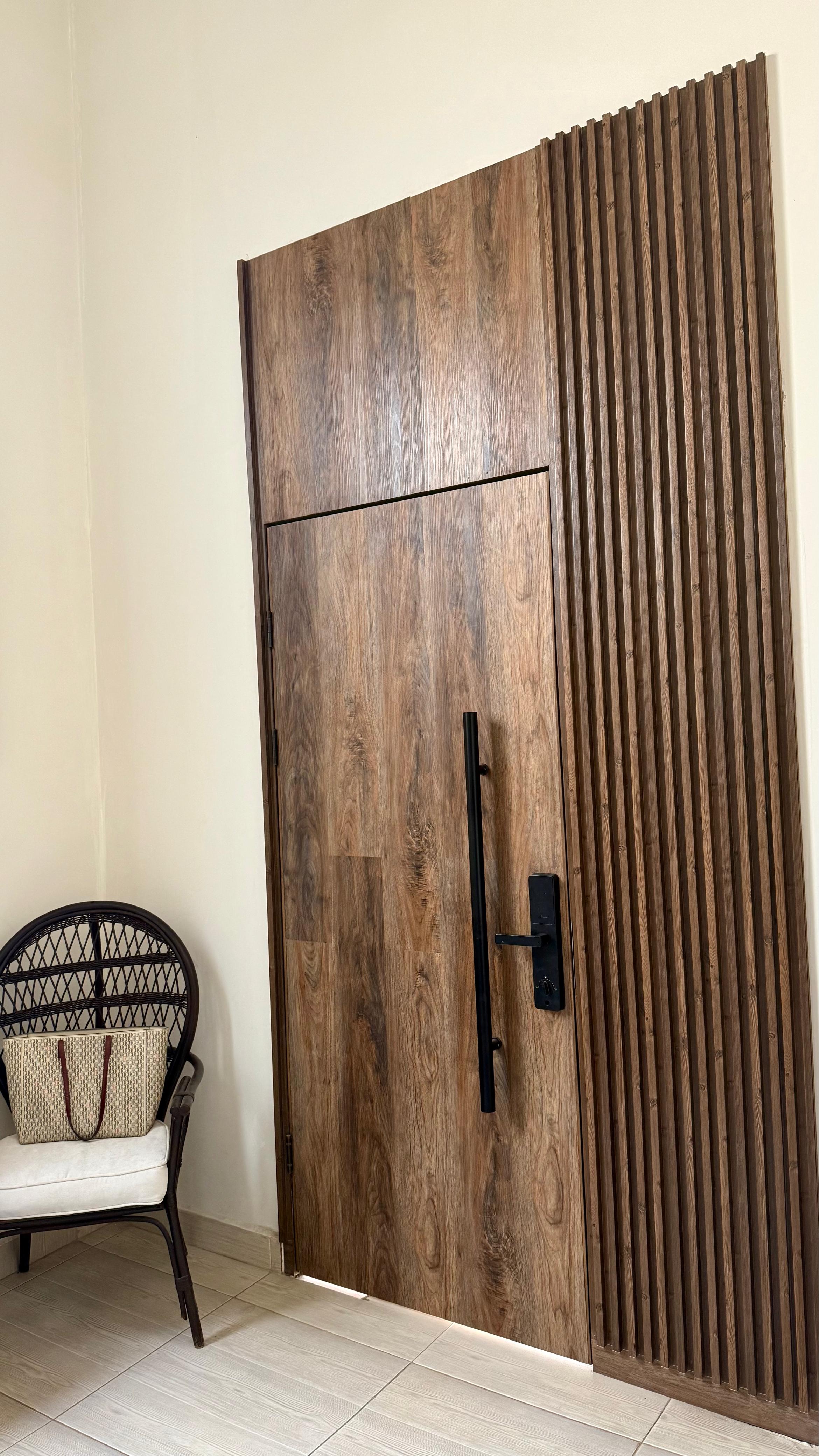 Puerta principal de madera con listones verticales — Torreón